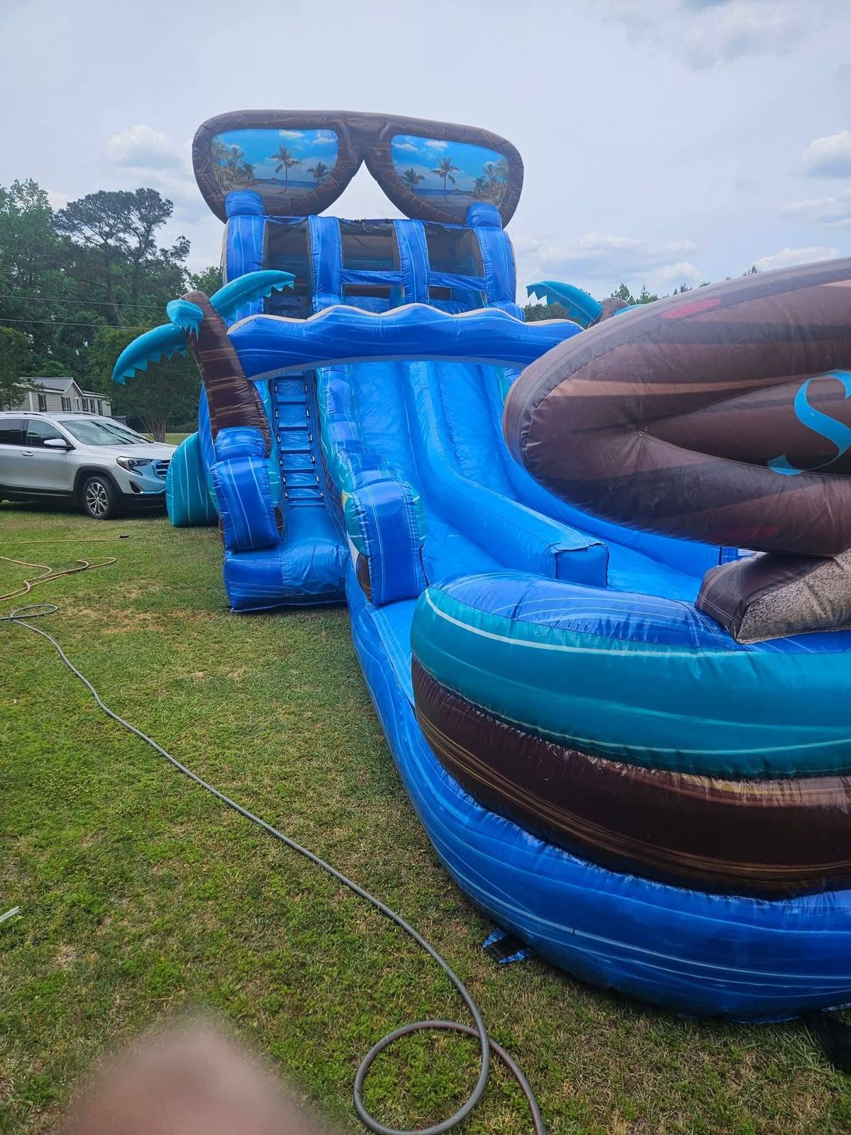 Two tropical-themed water slides set up in a grass yard