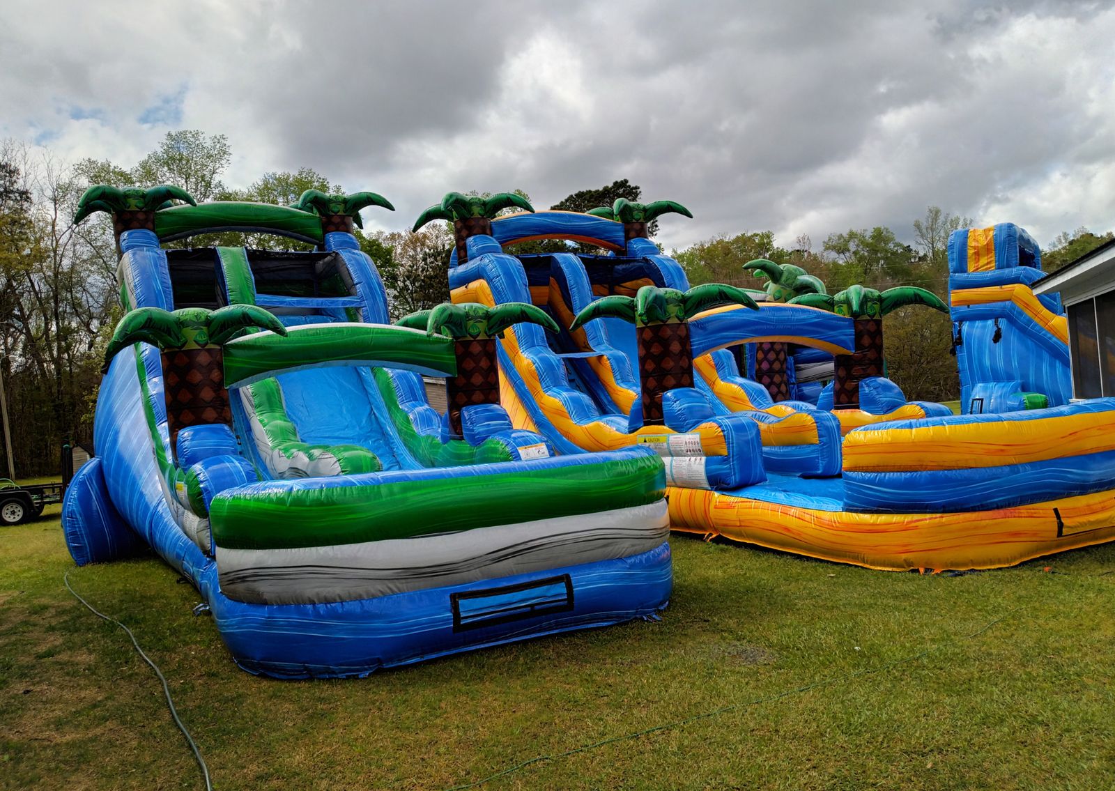 Multiple tropical-themed water slides set up on grass
